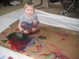 Finger paints on cardboard - a full body painting experience!