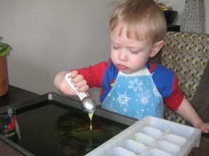 Once the ice cube tray was full to overflowing I told him we wouldn't add any more ingredients, so he started transferring everything to the cookie sheet instead. He started by pouring all the vinegar in, then carefully scooped the "sludge" as he called it and dribbled it into the pan as well. Fun!