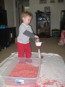 Back to rice in the sensory bin. He loves making constructions with funnels and old yarn cones to pour the rice through.